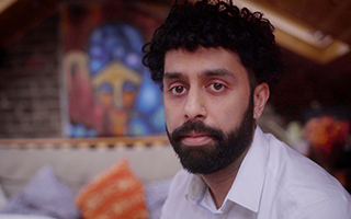 A man sitting in a room looking at the camera