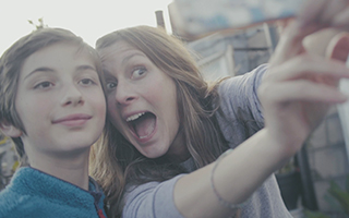Woman and a little boy smiling and taking a selfie together