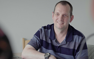 A man sitting at a table smiling