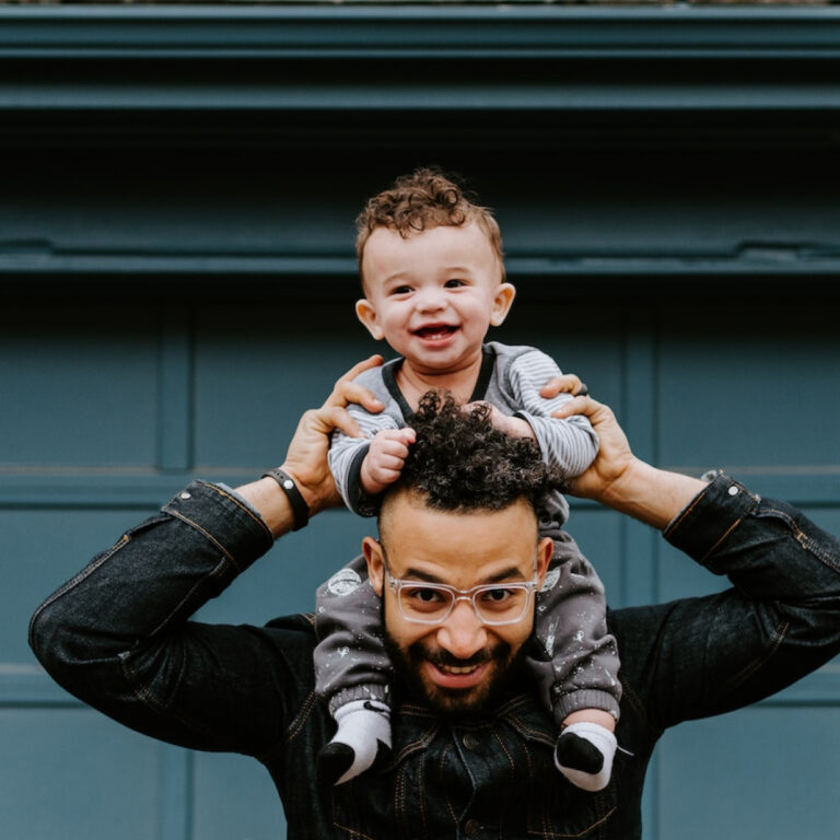 A man giving a piggyback to his infant son