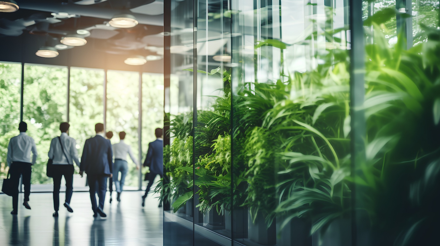 People leaving office with plants in foreground