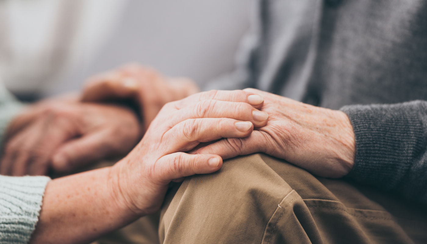 An elderly couple holding hands