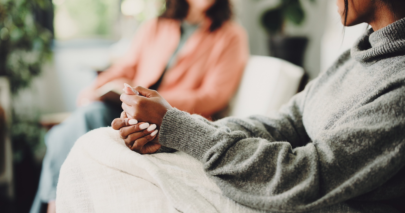 Hands of woman on sofa for counselling