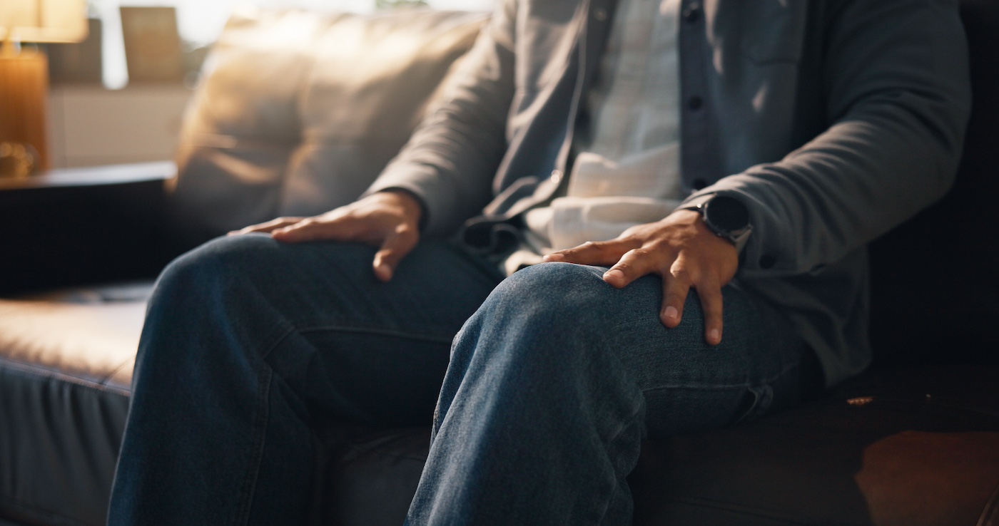 Hands of person on sofa in office for counselling