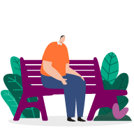 A man sitting on a bench, alone. His hands rest on his lap, and he looks down towards the ground.