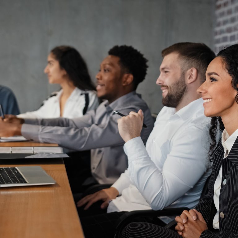 A team of office workers watching a webinar together in a boardroom.